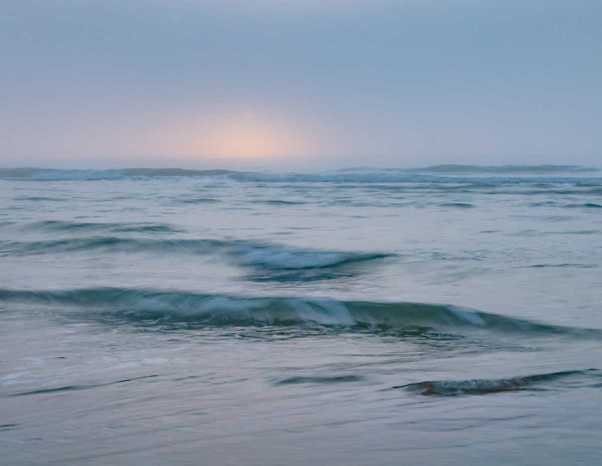 Foto van een rustig zee bij zonsondergang.