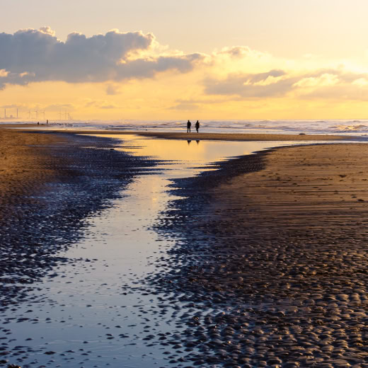 foto van een strandwandeling bij zonsondergang in Egmond.